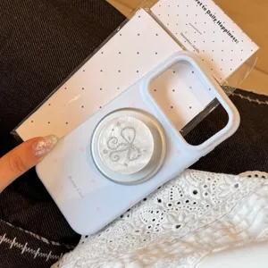 Detail van lichtblauwe iPhone-hoes met een fonkelende parelmoeren strik telefoonhouder.
