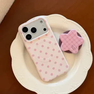 Détail de la coque iPhone magnétique à pois roses avec un support d'étoile à carreaux.