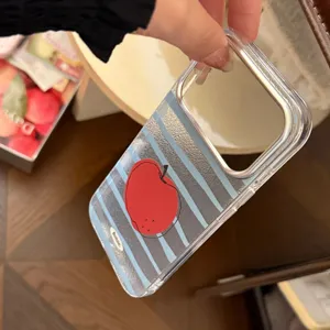 Vue rapprochée d'une coque transparente avec motif pomme rouge et rayures bleues sur bois