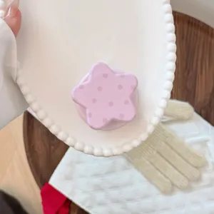 Vue détaillée d'un support de téléphone magnétique rose en forme d'étoile à pois violets