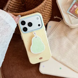 Gros plan détaillé d'une coque iPhone jaune pâle avec un support mignon en forme de poire
