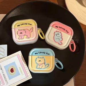 Tre simpatiche custodie AirPods con gatti cartone e anelli colorati su piatto nero