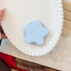 Gros plan d'un support de téléphone magnétique bleu à pois en forme d'étoile