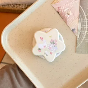 Primer plano de un soporte para teléfono en forma de estrella con diseño de conejo