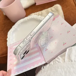 Vue détaillée du support fraise transparent sur une coque iPhone rose à carreaux