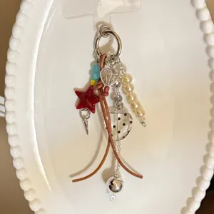 Vue détaillée d'une breloque faite main avec des perles cœur et étoile et des lanières en cuir