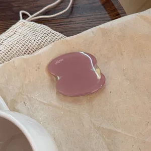 Detailopname van een stoffige roze onregelmatige geometrische telefoonhouder grip.
