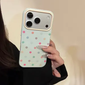 Primo piano della custodia per telefono a pois macaron tenuta da una mano.