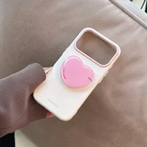 Détail d'une coque iPhone blanche élégante avec un support de téléphone rose en forme de cœur