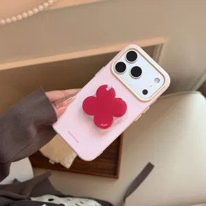 Coque iPhone rose avec un support de téléphone en forme de trèfle rouge et grip géométrique