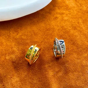 Nahaufnahme von gold- und silberfarbenen Ringen mit Hammerschlag-Struktur und Seildetail