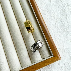 Detailansicht breiter, gehämmerter Ringe mit gedrehtem Seilakzent in Gold und Silber