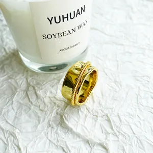 Nahaufnahme eines goldfarbenen Designer-Rings mit gedrehtem Seilmuster-Detail