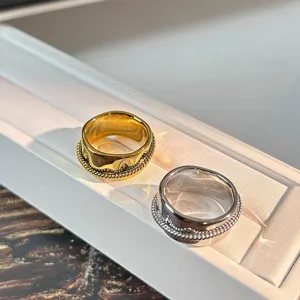 Nahaufnahme von gold- und silberfarbenen Ringen mit Seildetail auf weißem Display
