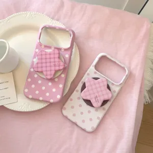 Gros plan sur une coque iPhone rose à pois avec un support de téléphone en forme d'étoile
