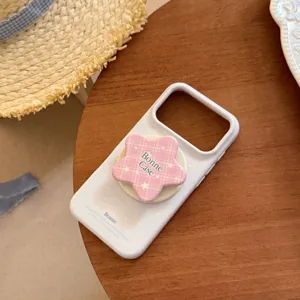 Détail du support d'étoile à carreaux roses sur coque iPhone bleu clair avec marque Bonne