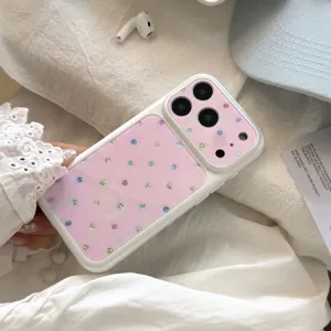 Détail d'une coque iPhone de style coréen avec des pois en strass colorés sur fond rose