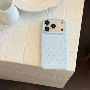 Gros plan sur une coque iPhone bleu clair avec pois roses et anneau magnétique intégré