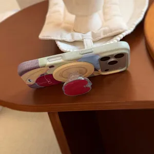 Zijaanzicht van een iPhone-hoesje met fruitpatroon en een geïntegreerde rode standaard.