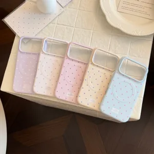 Détail macro de cinq coques iPhone magnétiques mates à pois colorés sur une table blanche