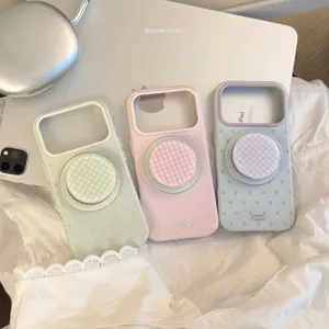 Détail de trois coques MagSafe pastel avec pois et supports en vichy rose et vert.