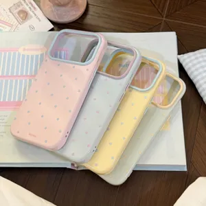 Gros plan de quatre coques à pois de couleur macaron pour iPhone sur un magazine