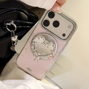 Vue détaillée d'une coque iPhone rose avec miroir cœur en métal liquide et MagSafe.