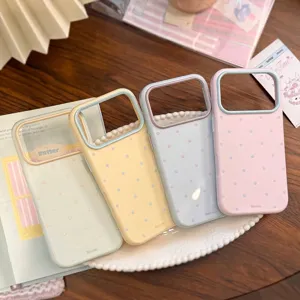 Détail de quatre coques iPhone à pois aux couleurs macaron dans un décor lifestyle.