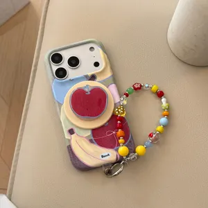 Close-up van kleurrijke fruit doodle iPhone-hoes met kralenband en appel pop-socket
