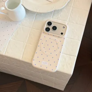 Vue détaillée de la coque iPhone magnétique à pois crème sur une surface carrelée