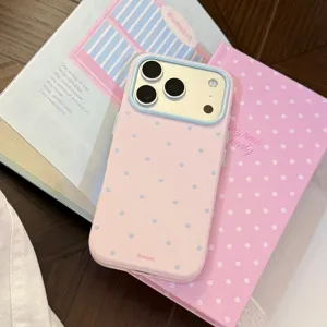 Gros plan sur la coque iPhone rose à pois avec détails du cadre photo bleu clair.