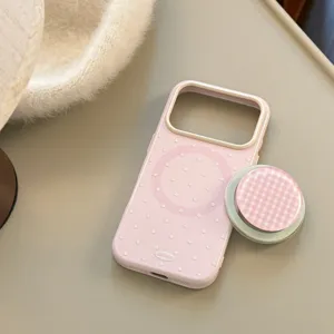Zoom sur une coque MagSafe rose à pois avec son support pop socket assorti