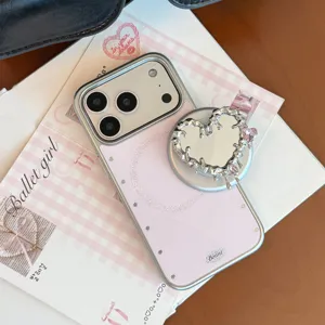 Détail d'une coque iPhone rose avec support miroir en métal en forme de cœur et strass