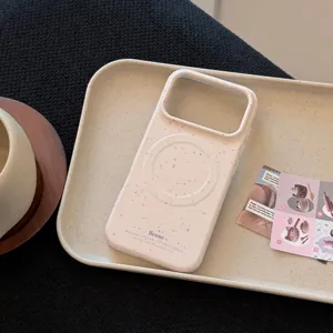 Gros plan d'une coque iPhone crème avec un motif moucheté rose élégant et anneau magnétique