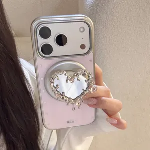 Vue détaillée du support magnétique cœur en argent sur une coque de miroir rose pour iPhone