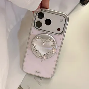 Coque iPhone argentée avec support magnétique en forme de cœur fondu et gemmes roses.