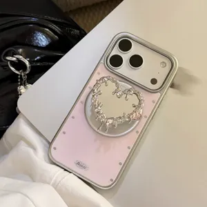 Détail de coque iPhone rose avec support miroir cœur liquide argenté et strass