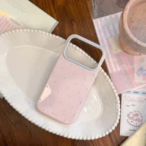 Gros plan de la coque rose macaron avec pois bleus et texture souple pour iPhone