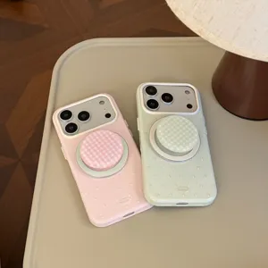 Détail de coques iPhone à pois rose et vert menthe avec supports magnétiques sur bureau