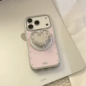 Détail d'une coque iPhone rose avec un support magnétique en forme de cœur argenté liquide
