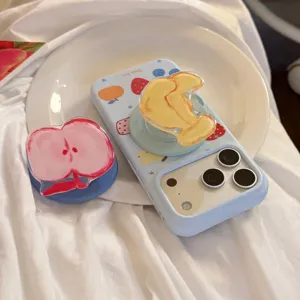 Close-up of blue iPhone case featuring fruit graffiti and 3D acrylic fruit pop sockets.