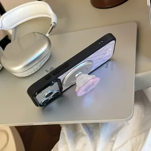 Détail d'une coque iPhone en nacre violette avec un support de prise magnétique intégré.