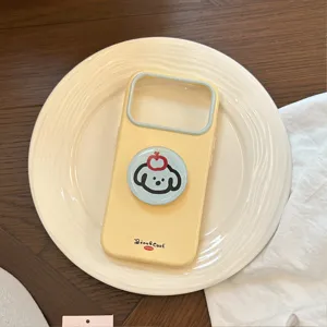Détail d'une poignée de chien mignonne sur une coque iPhone crème posée sur une assiette
