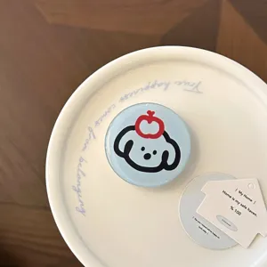 Vue rapprochée d'un support de téléphone mignon avec un motif de chien et pomme