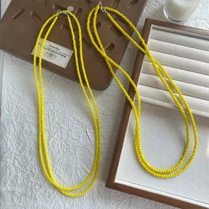 Primo piano di una vivace collana di perle gialle a più strati con pietre sfaccettate