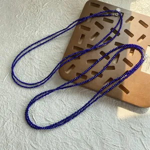 Dettaglio della collana di perline di spinello blu intenso sfaccettate per look a strati.