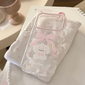 Detail view of transparent phone case featuring a cute cream puppy and pink bow.