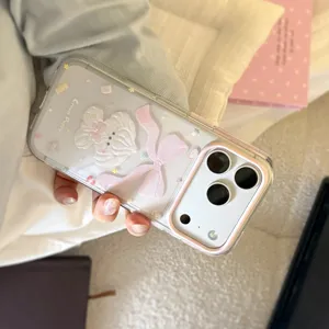 Close-up detail of cute cream puppy iPhone case with pink bow and glitter finish