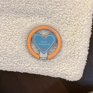 Detailed view of a trendy heart-shaped phone grip in vibrant blue and orange colors