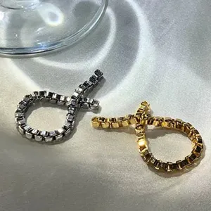 Nahaufnahme von minimalistischen Gold- und Silber-Boxketten-Crossover-Ringen für Damen